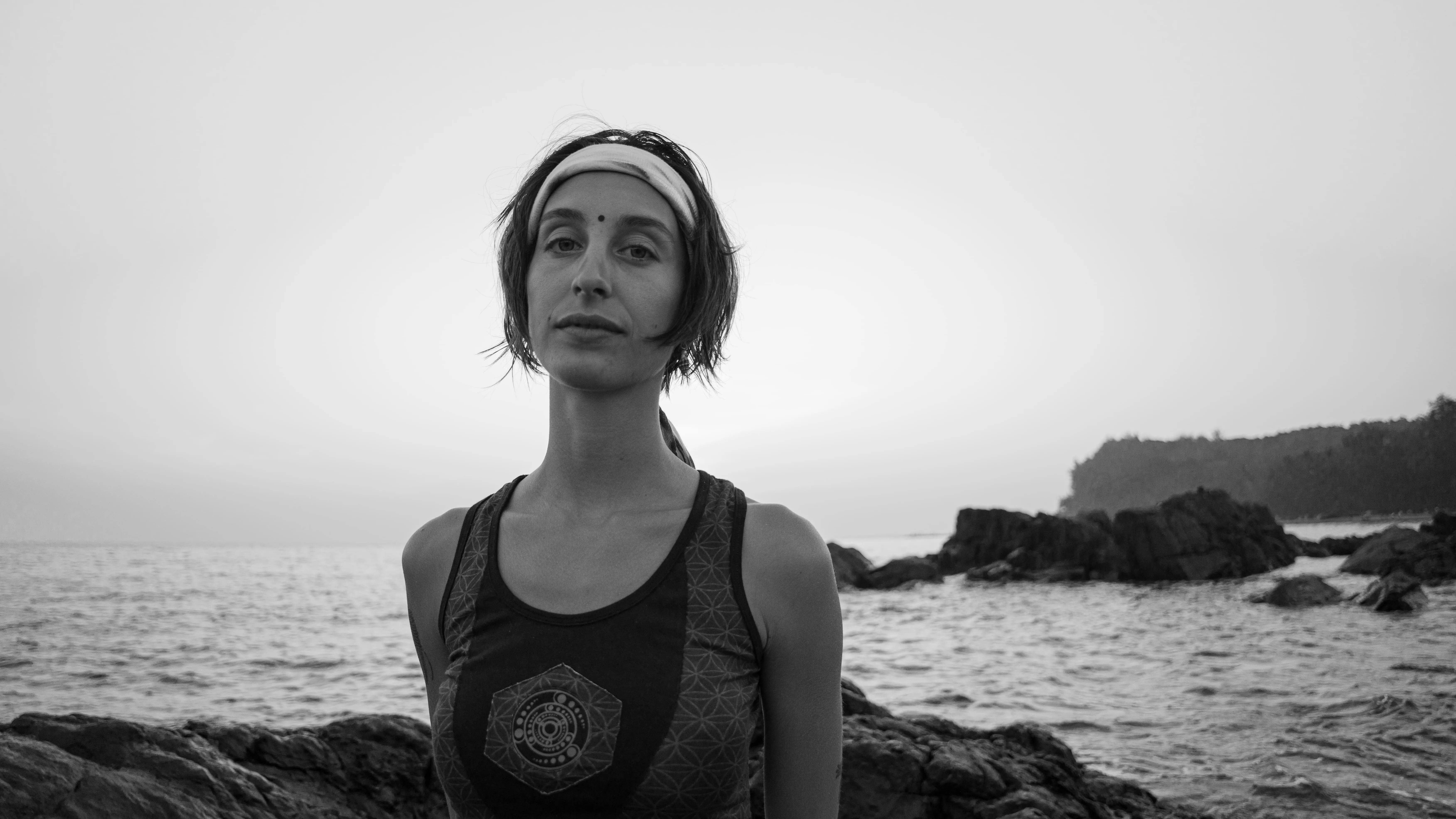 Black-and-white portrait of a woman wearing a headband on a Goa beach.