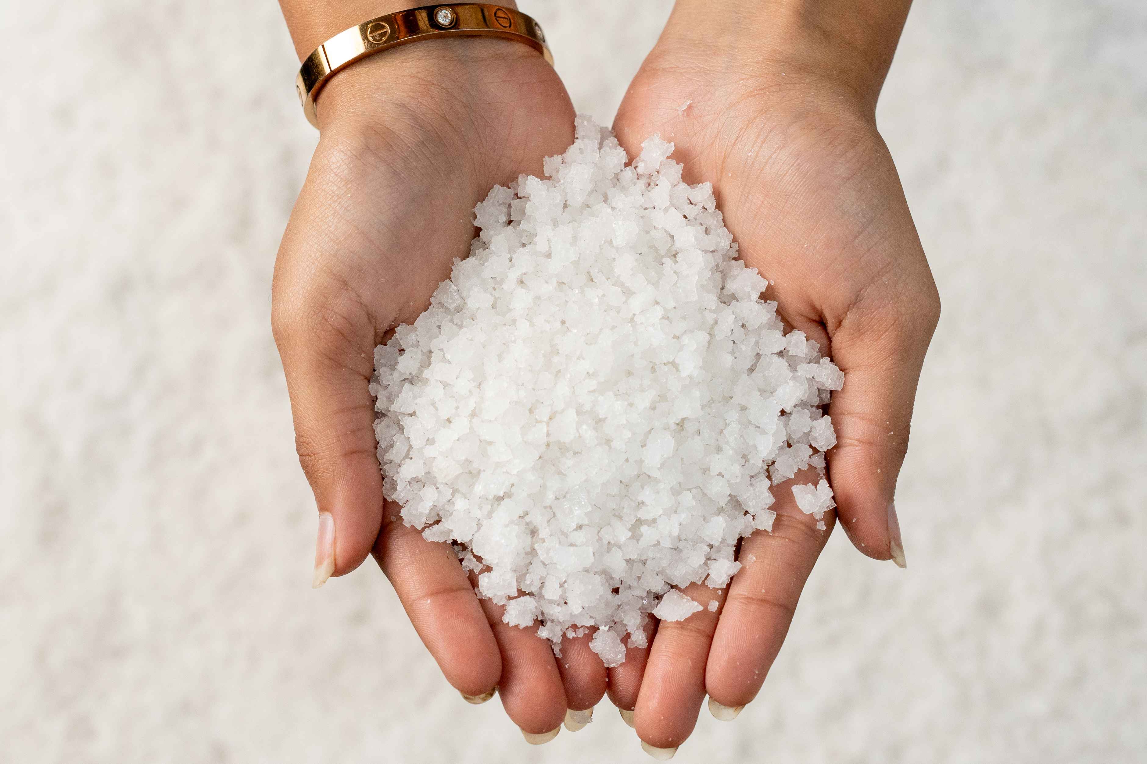 Hands holding Crystal Salt grains for Eva Chemlinks.