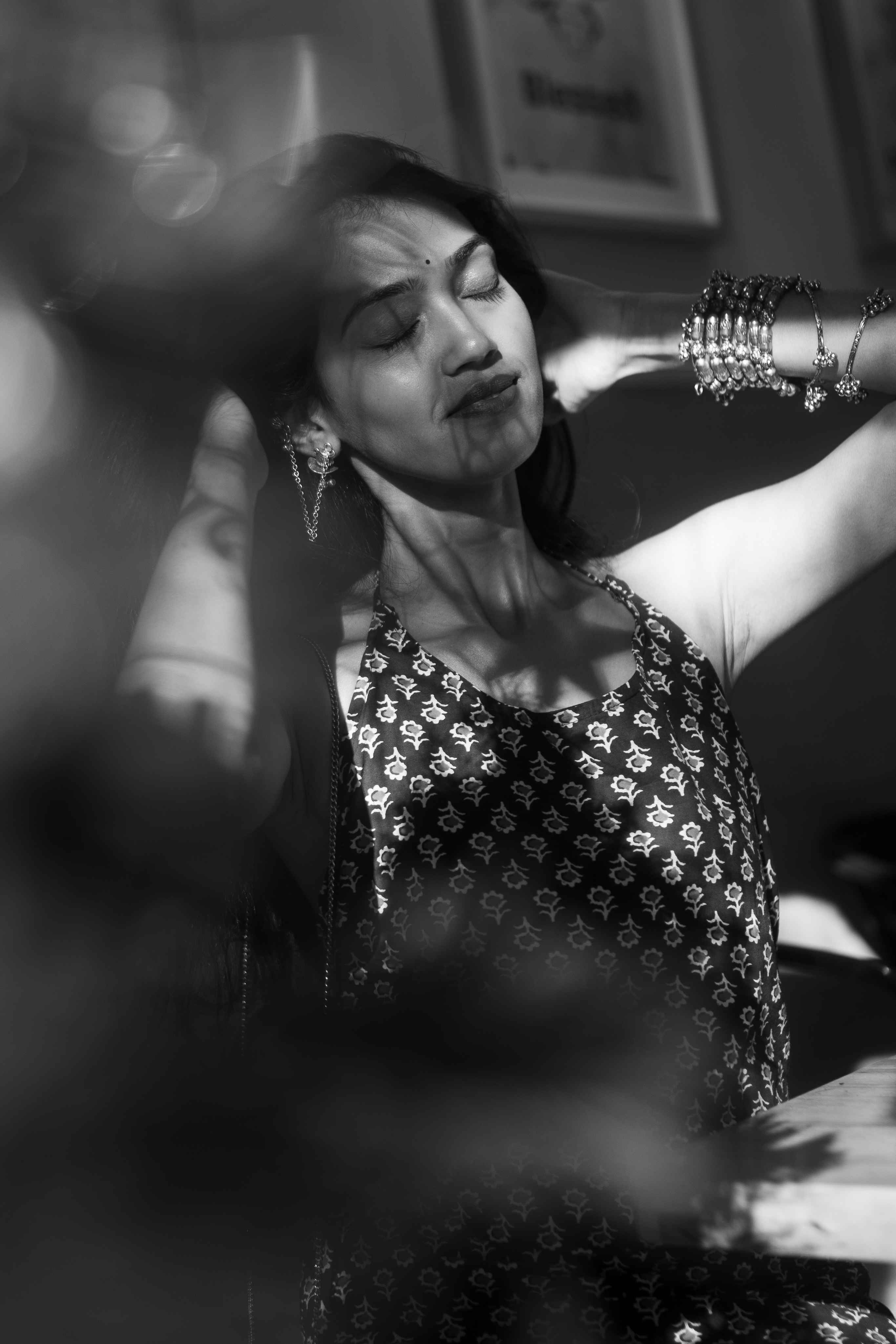 Black-and-white portrait of a woman in a patterned dress wearing jewellery.