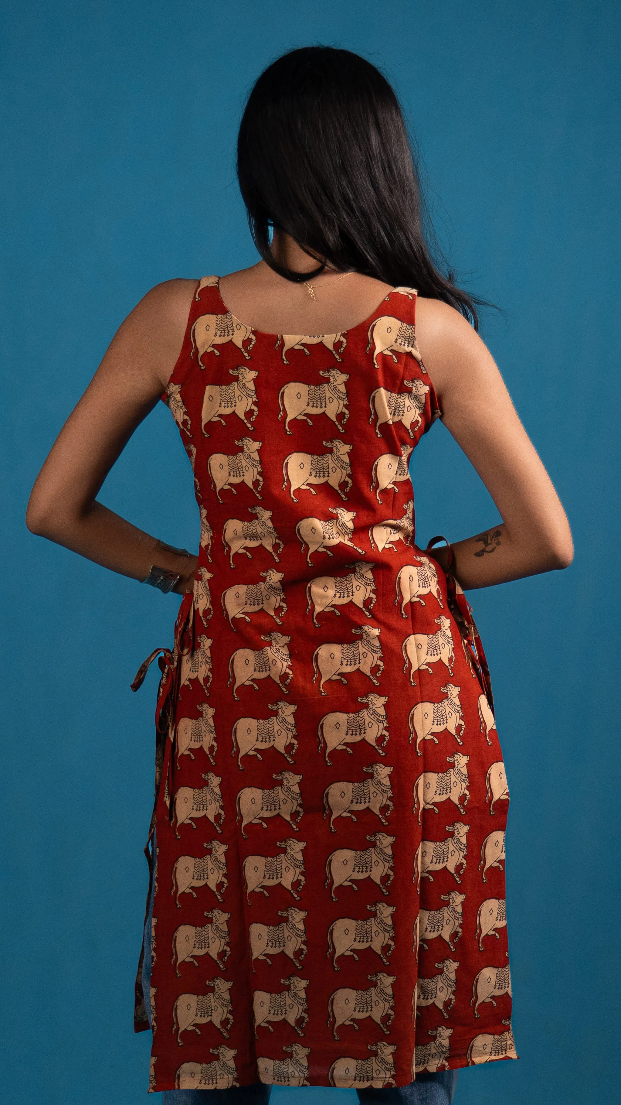 Back view of a red cow-print sleeveless top for Indyvarna's collection photography.