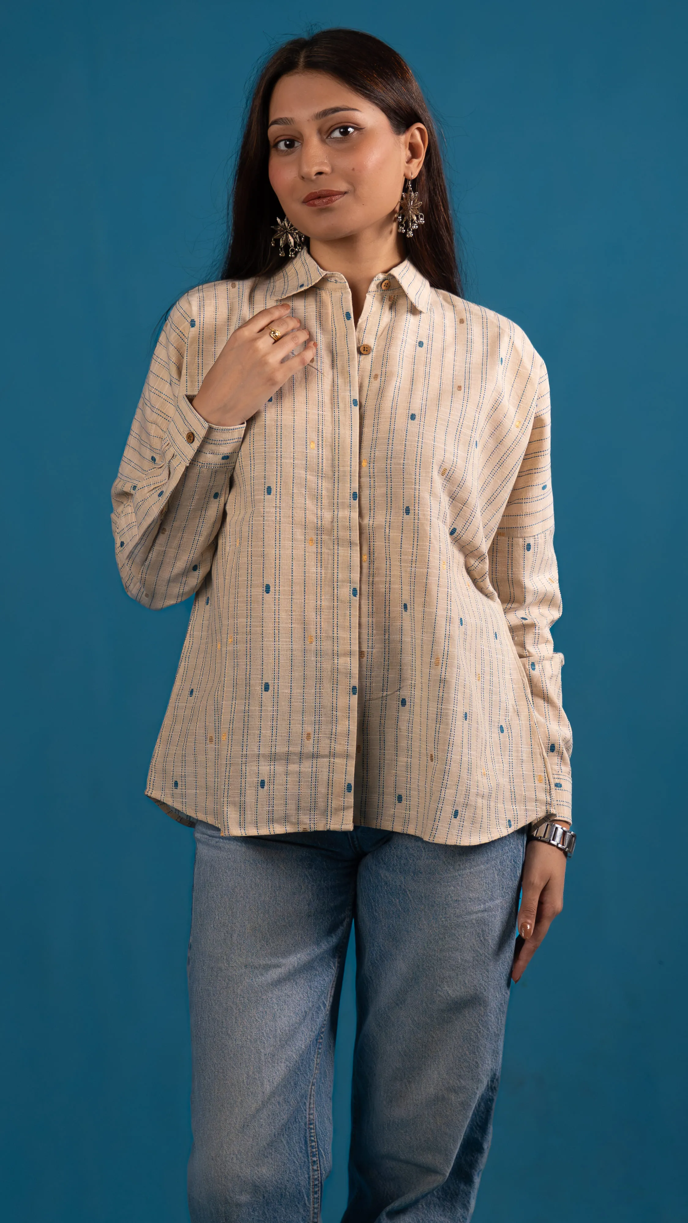 Woman in a cream striped button-up shirt for Indyvarna's collection photography.