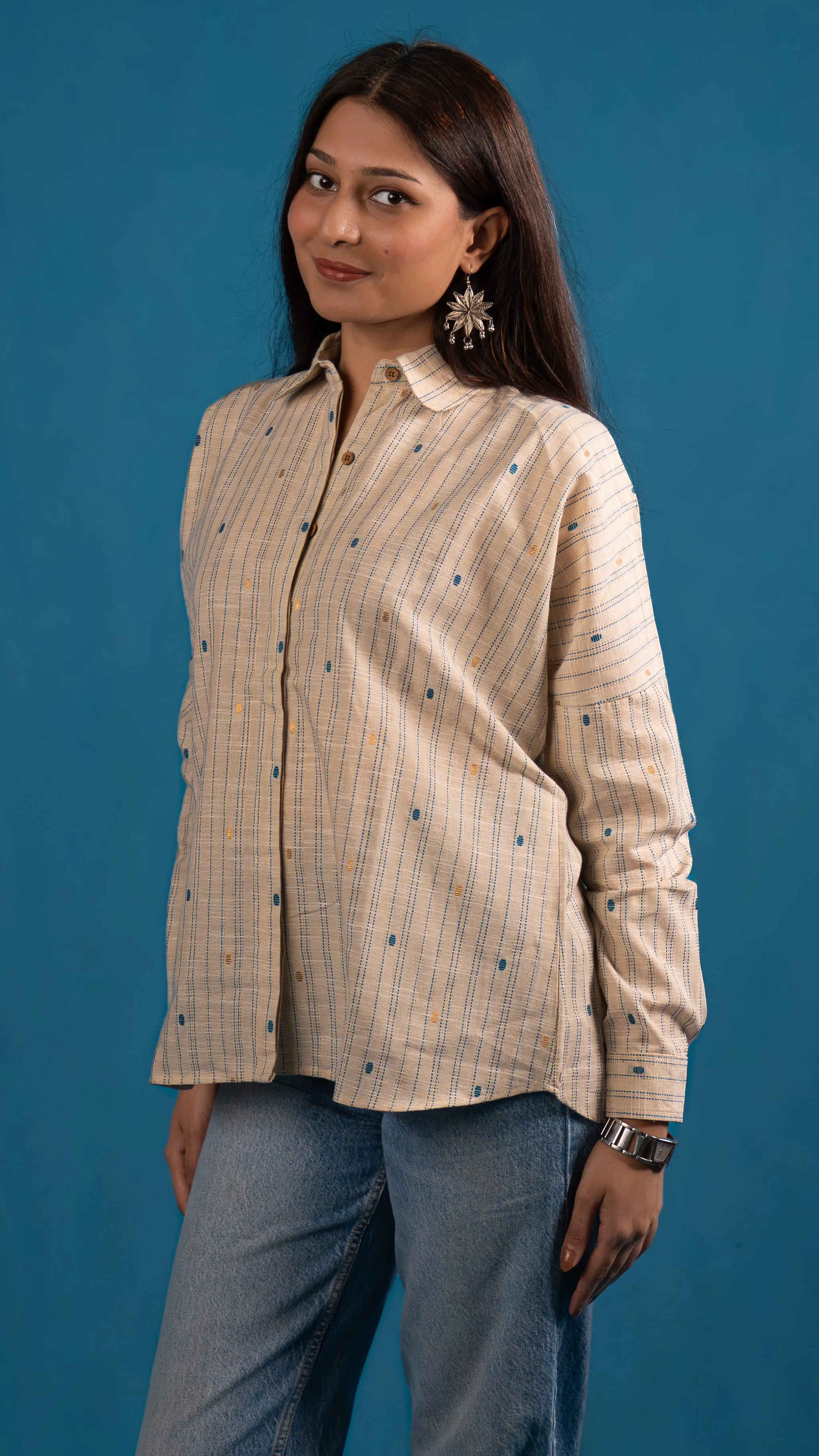 Three-quarter portrait of a cream striped button-up shirt for Indyvarna.