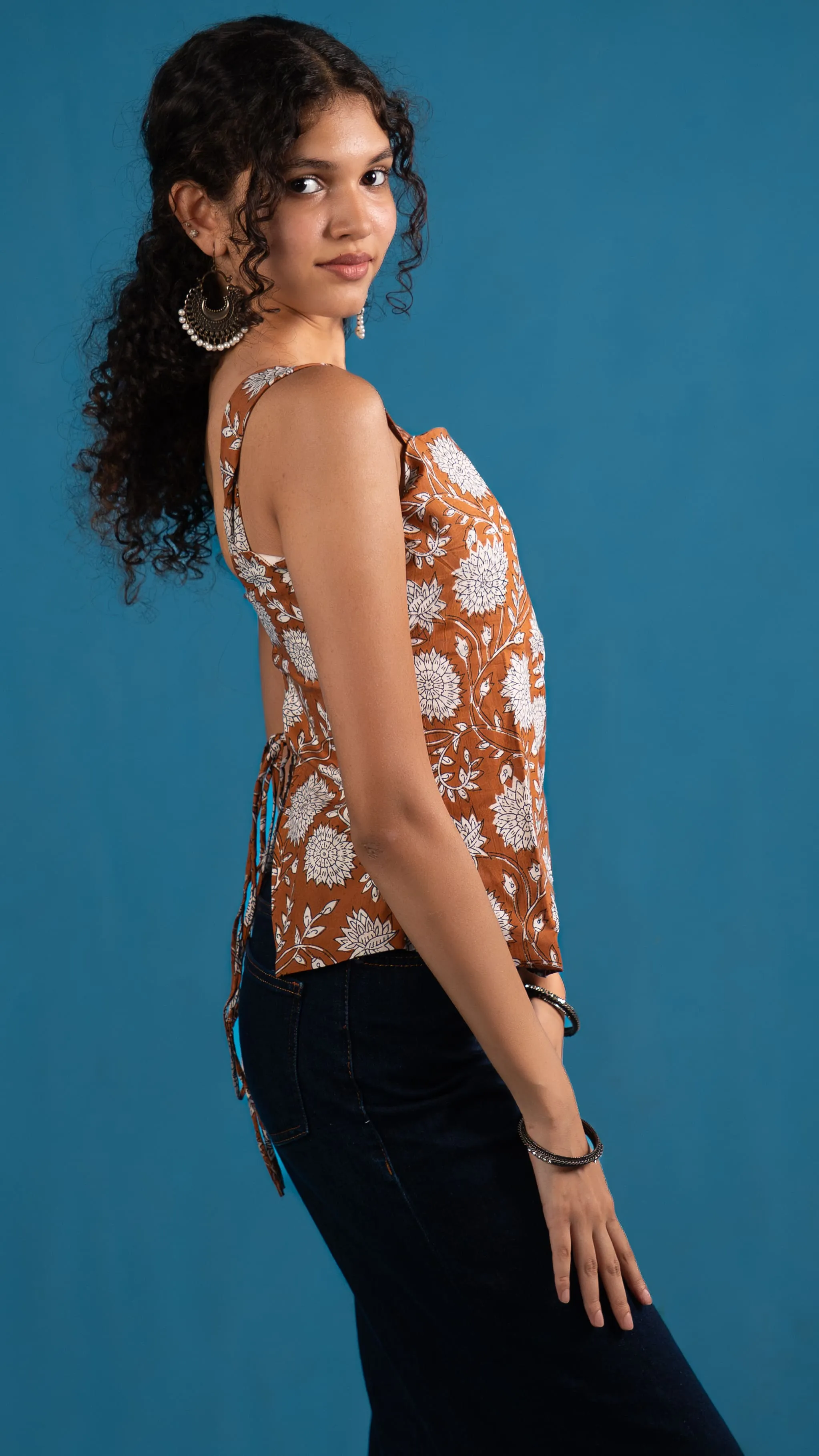 Side view of an orange floral sleeveless top for Indyvarna.