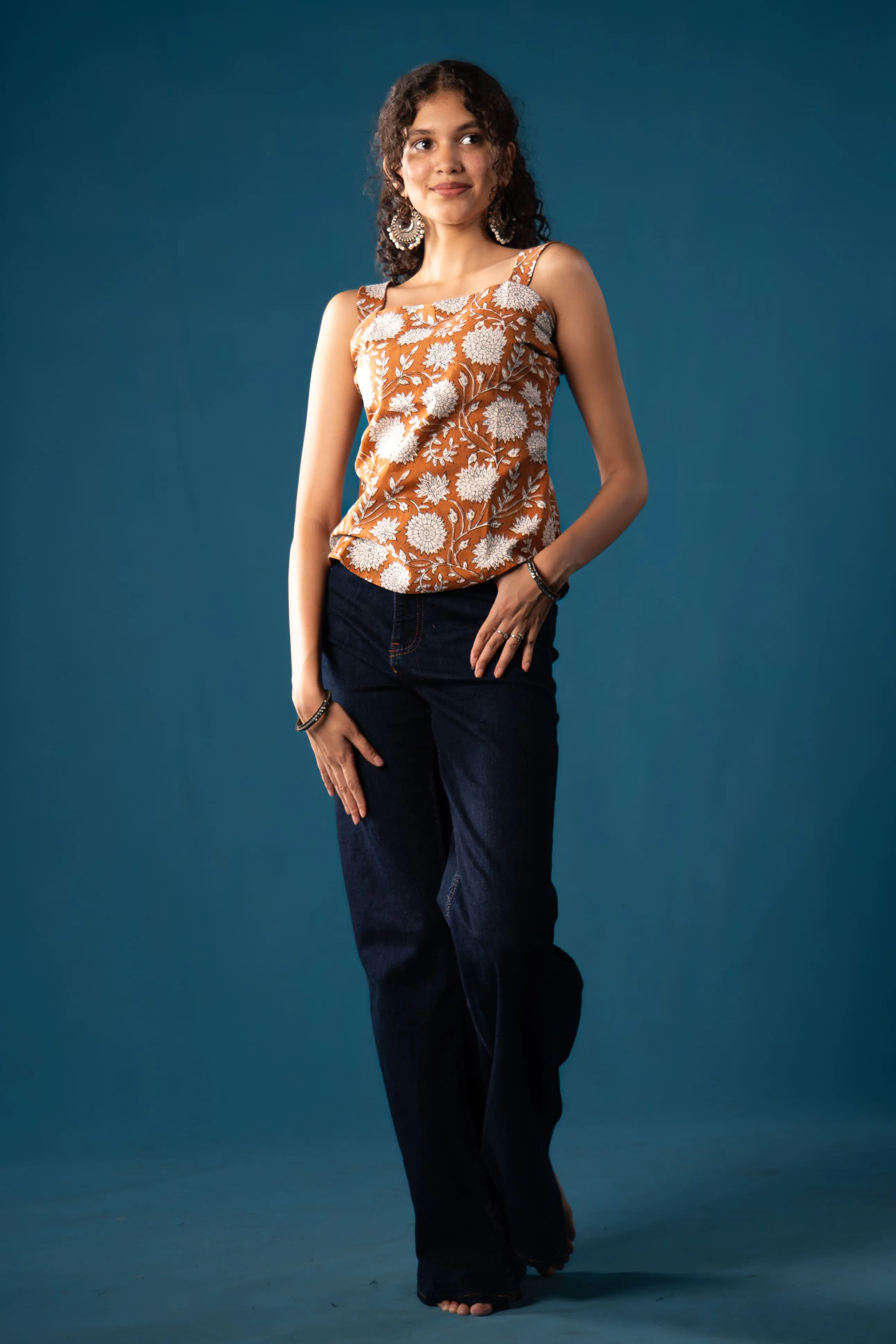 Woman in a rust-orange floral sleeveless top for Indyvarna's collection photography.