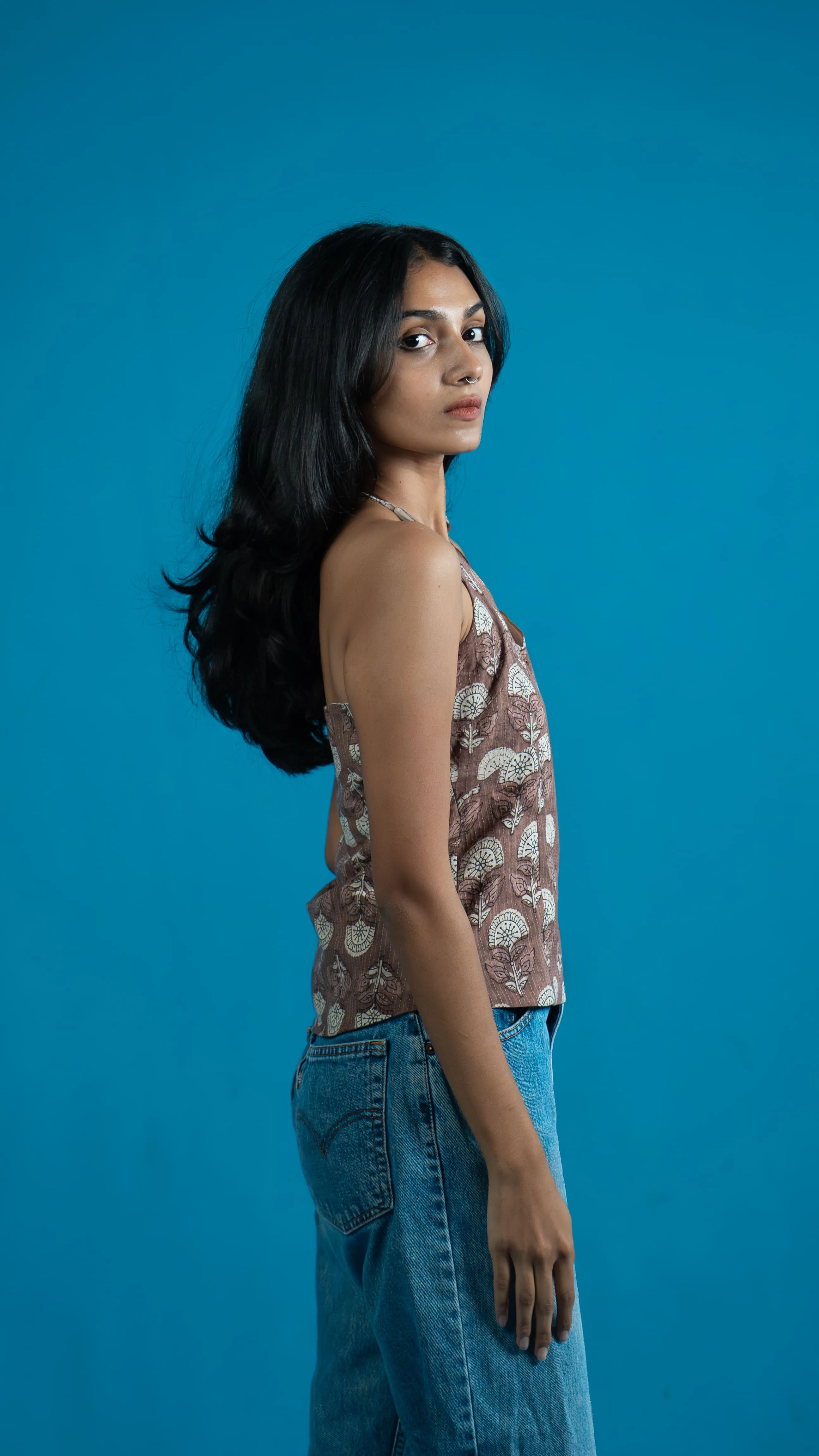 Side view of a brown patterned sleeveless top for Indyvarna.