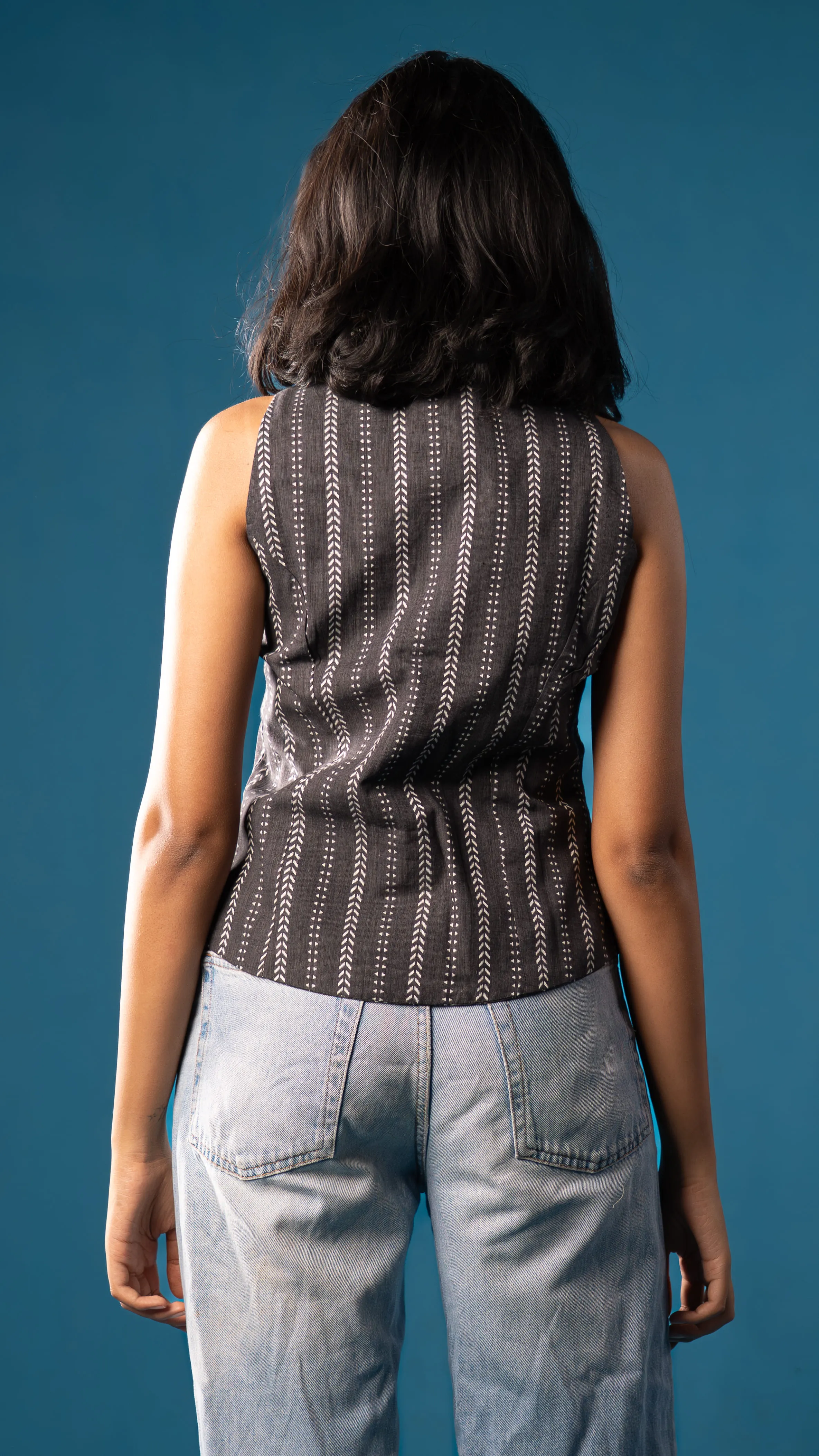 Back view of a black sleeveless patterned top for Indyvarna.