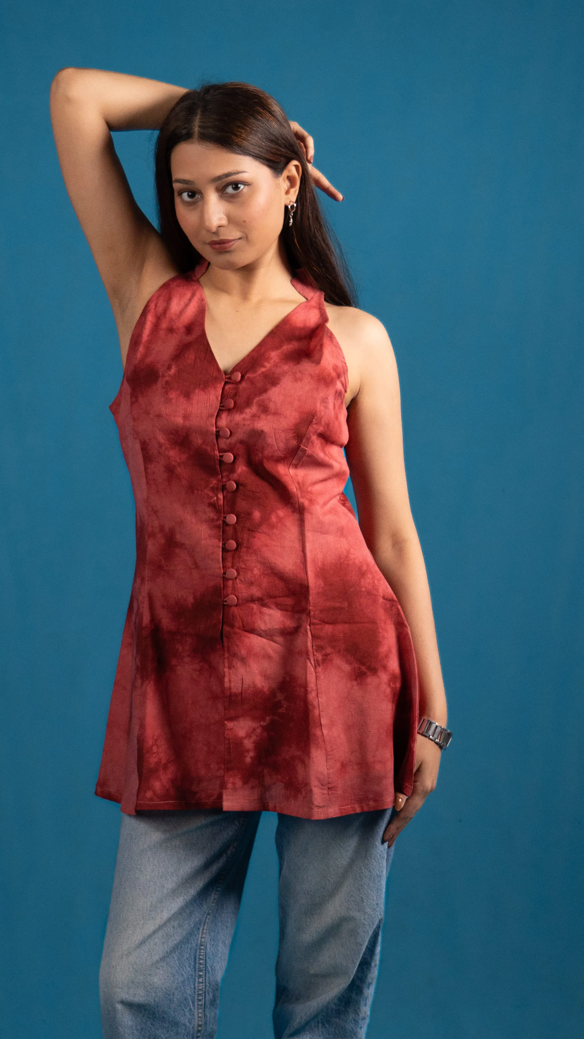 Woman in a red tie-dye sleeveless top with her eyes closed for Indyvarna.
