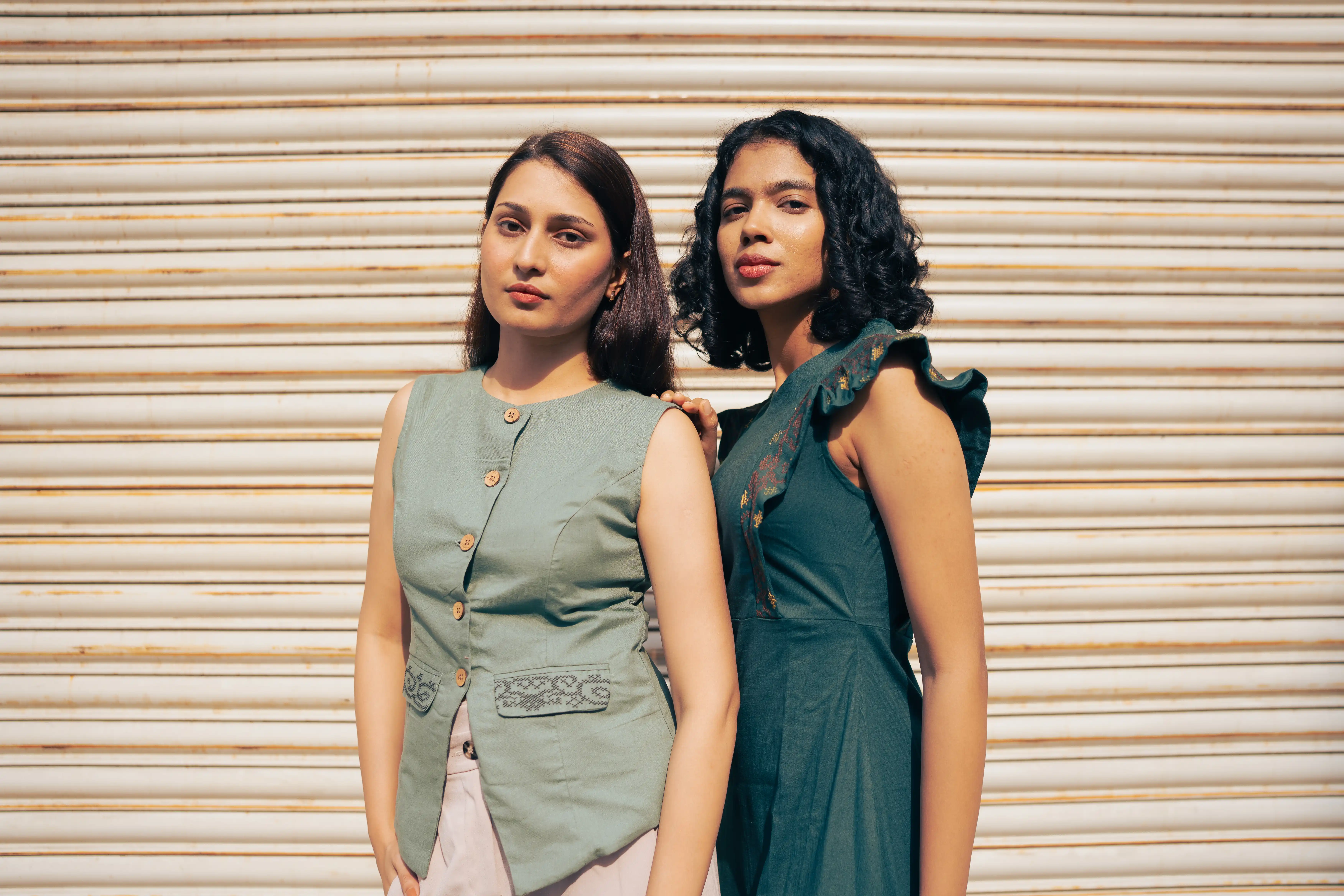 Two women in green sleeveless outfits for Indyvarna's collection photography.
