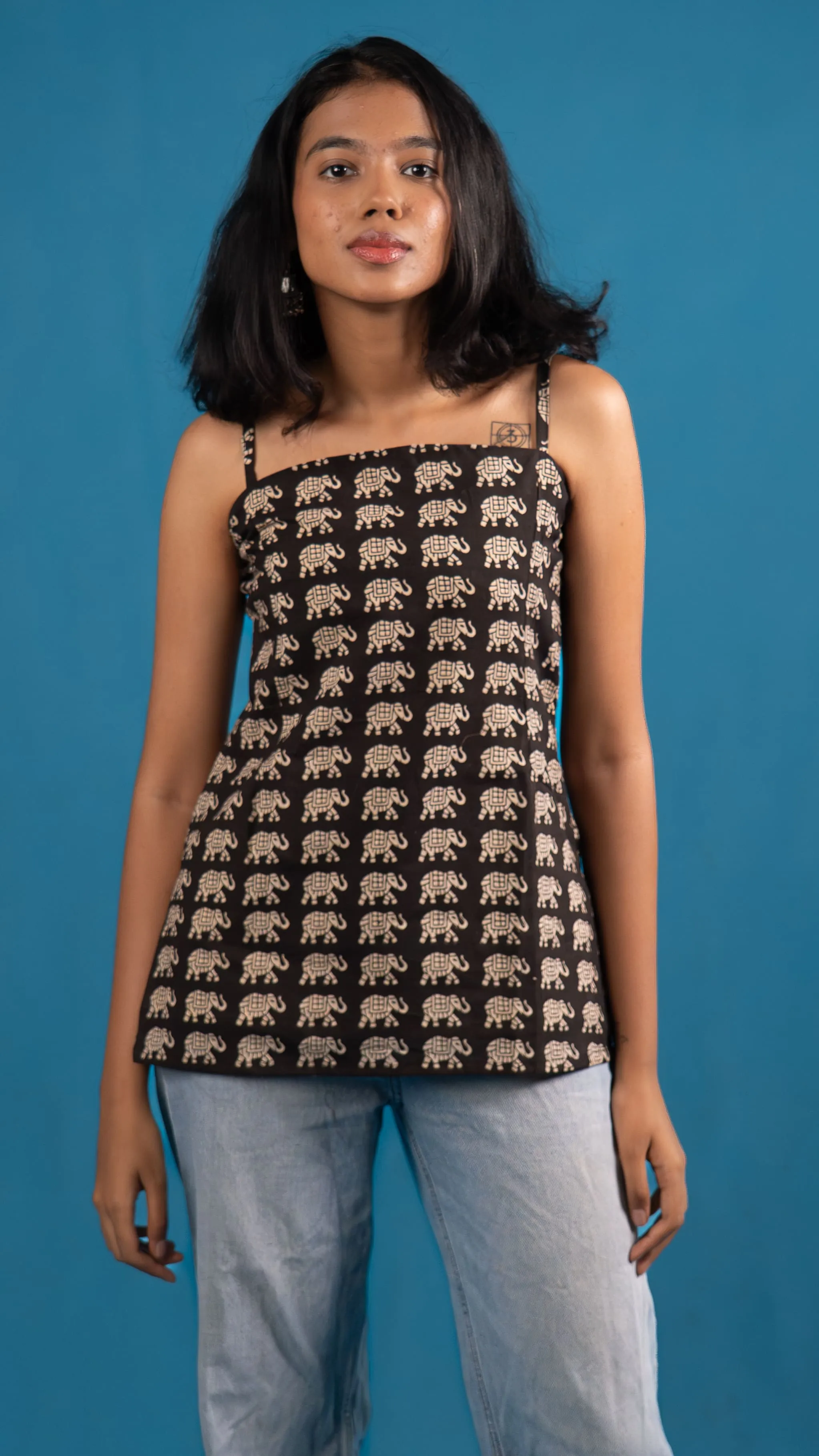 Woman in a black elephant-print spaghetti-strap top for Indyvarna's collection photography.