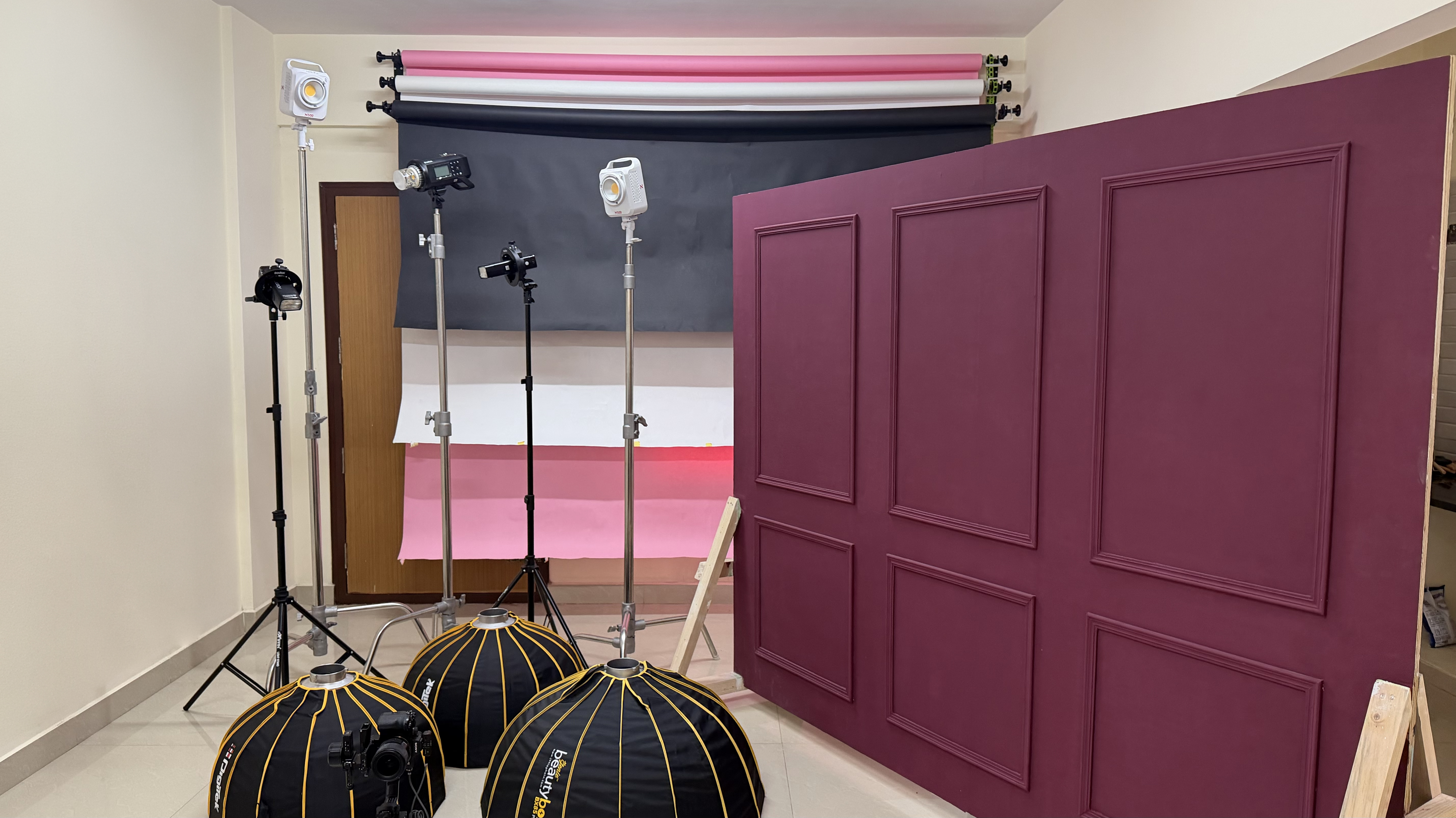 A taller angle of the same rental studio interior shows the backdrop stand, beauty-dish lights, and octagonal softboxes on the floor.