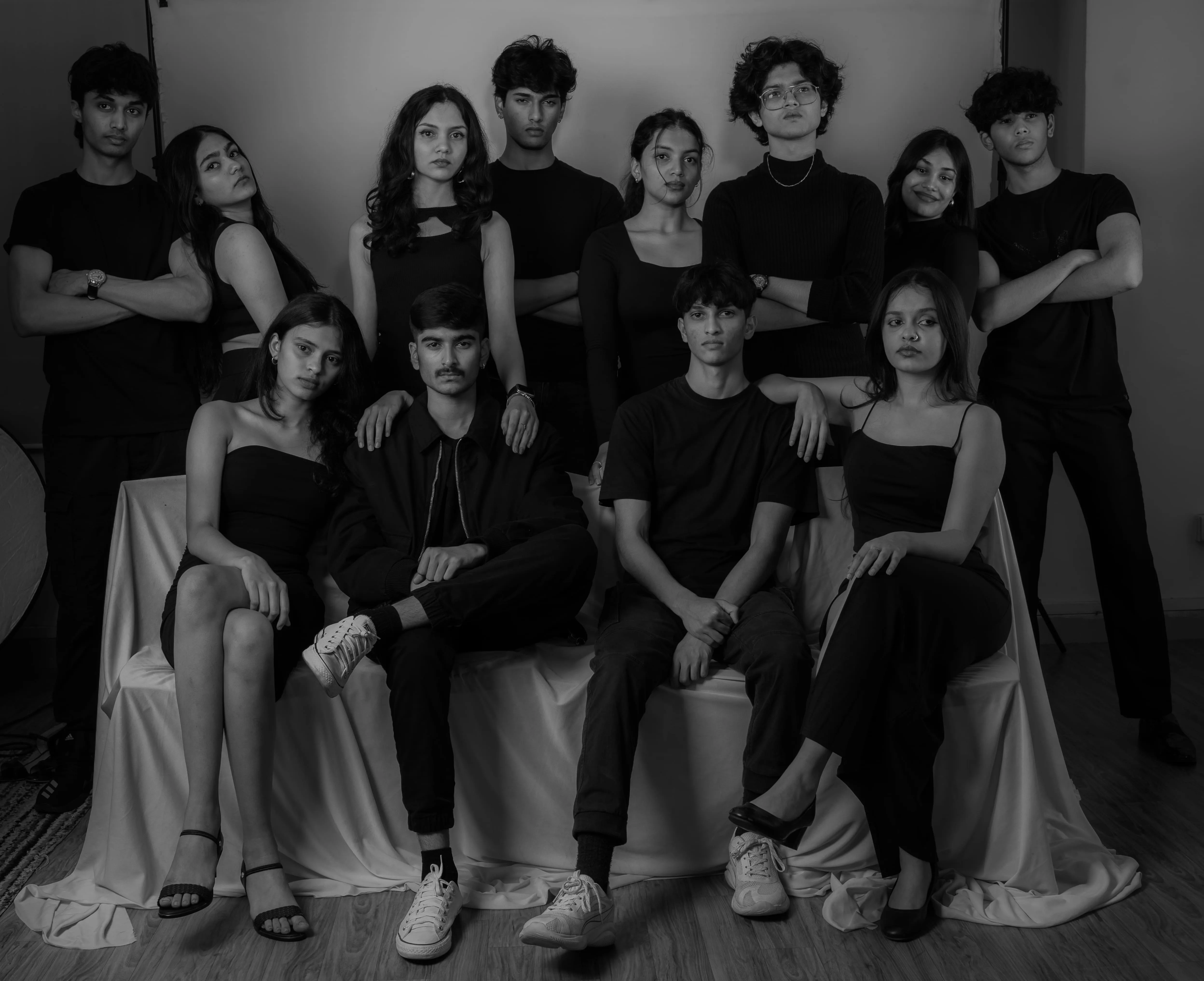 Twelve people in black pose for a studio group portrait in a model team photography project.