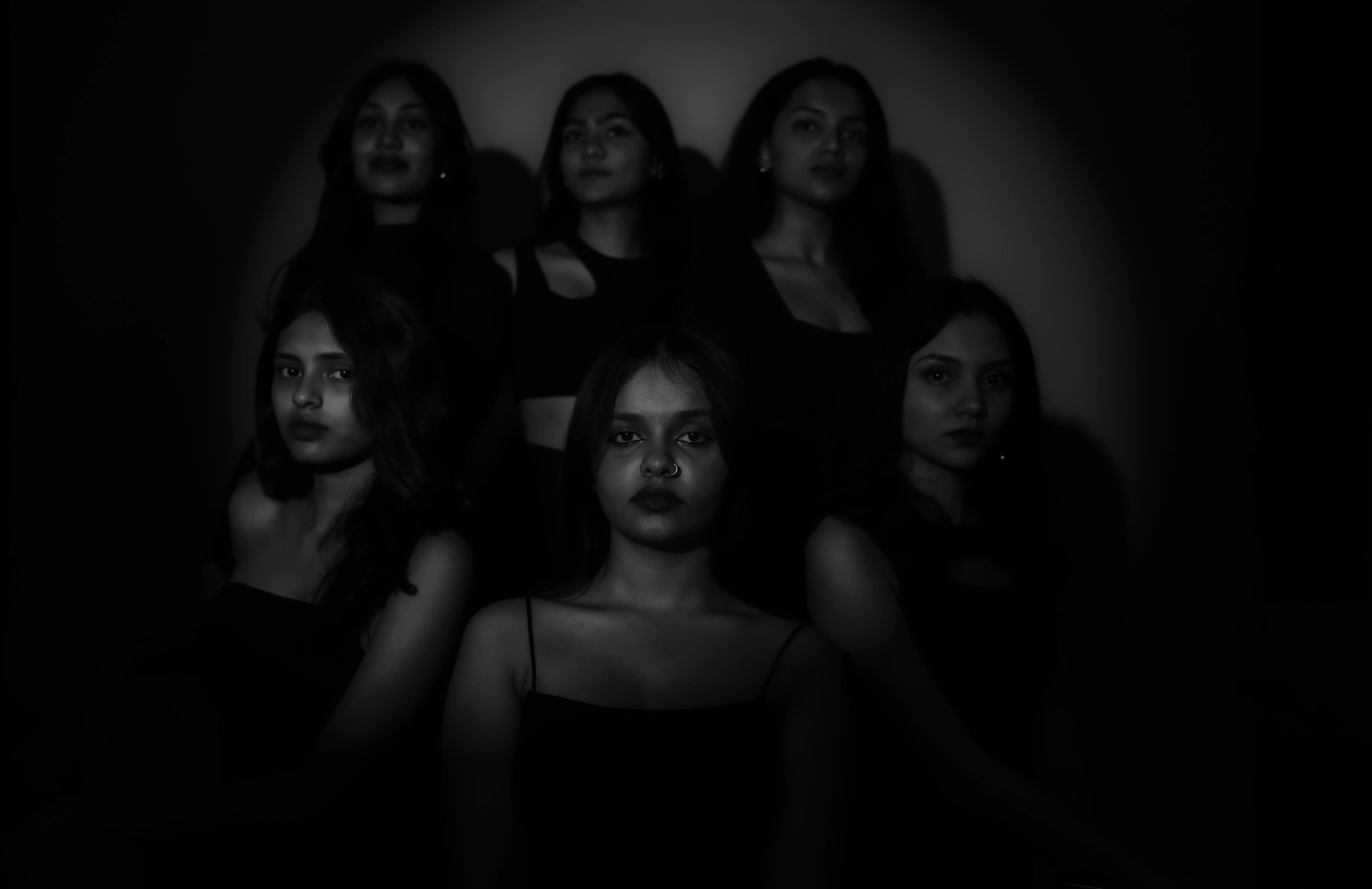 Six women in black pose in a low-key studio portrait for a model team photography project.